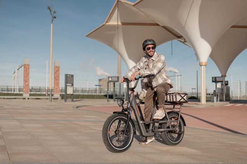 Man on a charcoal RadRunner 3 plus electric bike in an outdoor amphitheater