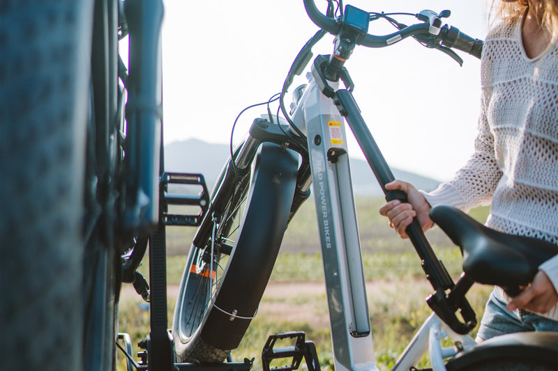 A person uses a Bike Adapter Bar to load an ebike onto an RV rear rack