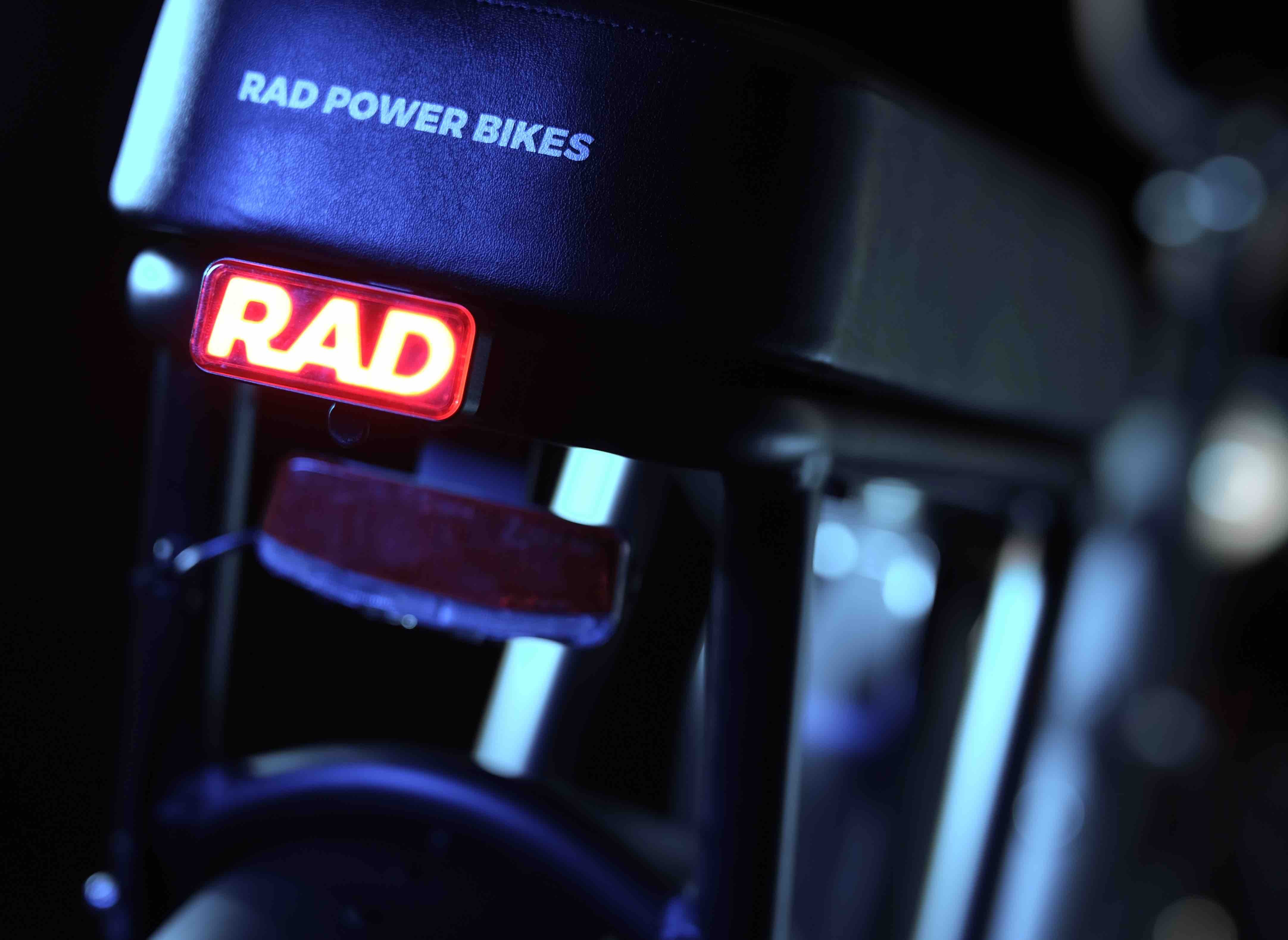 A close-up of a red light on the back of an ebike that says "Rad"