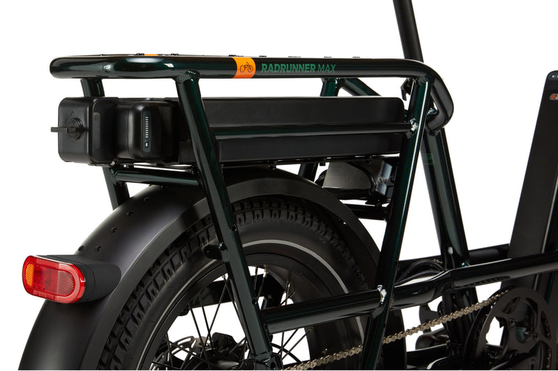 A green ebike with a black range extender installed with a battery in it. 