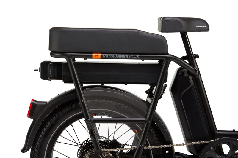 A black ebike with a range extender and battery installed under the passenger seat rear rack. 