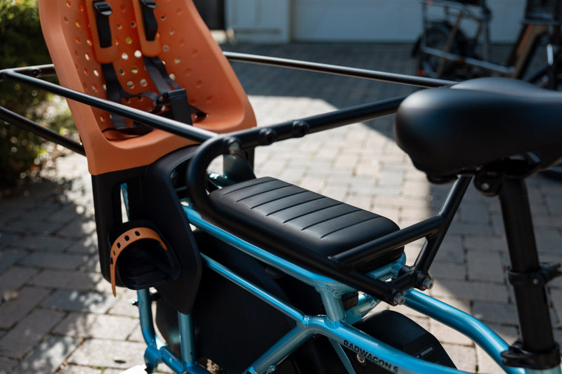 RadWagon 5 Deckpad installed on a blue RadWagon 5 electric cargo bike, with an orange thule yepp chilld seat and a caboose installed.